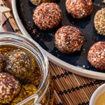 Paneer labneh balls in a jar and on a plate coated in different seasonings ready to serve