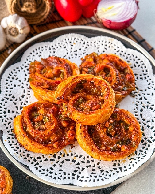 close up shot of the golden crispy schezwan paneer pinwheels served